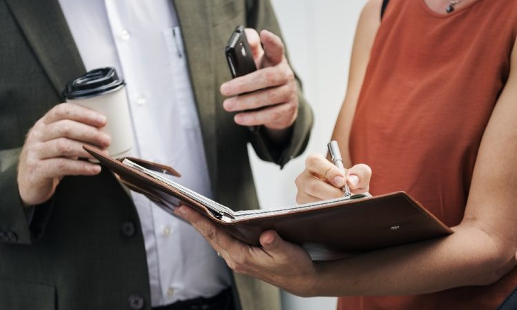 man explaining contract to woman signing papers